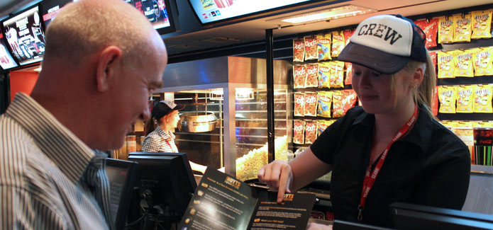 Hoyts employee pointing out menu items to a customer