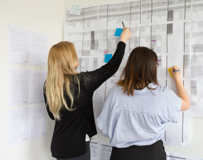 Two Proto experience designers working on a customer experience journey map