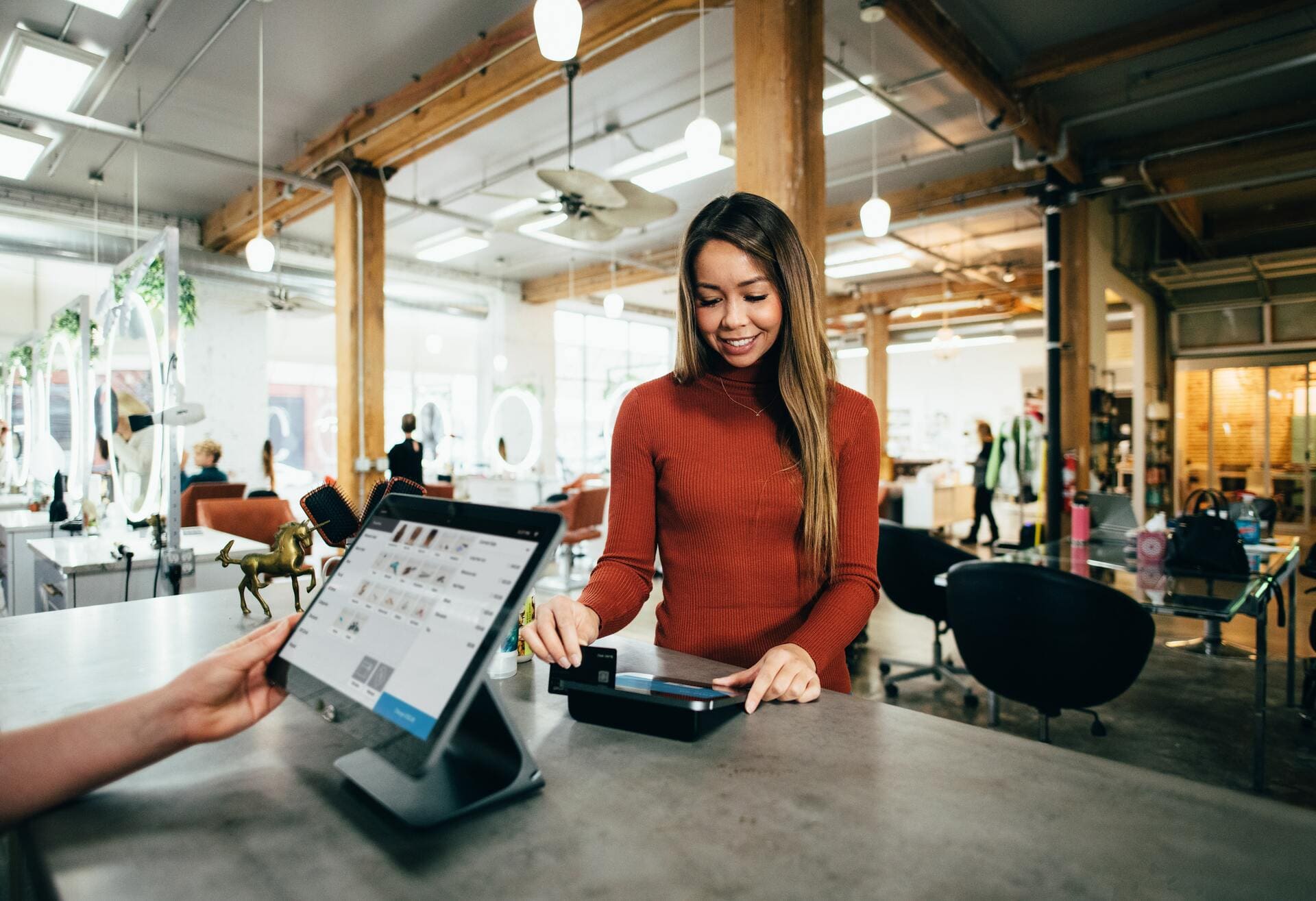 Lady smiling as she pays for her purchase at the register.