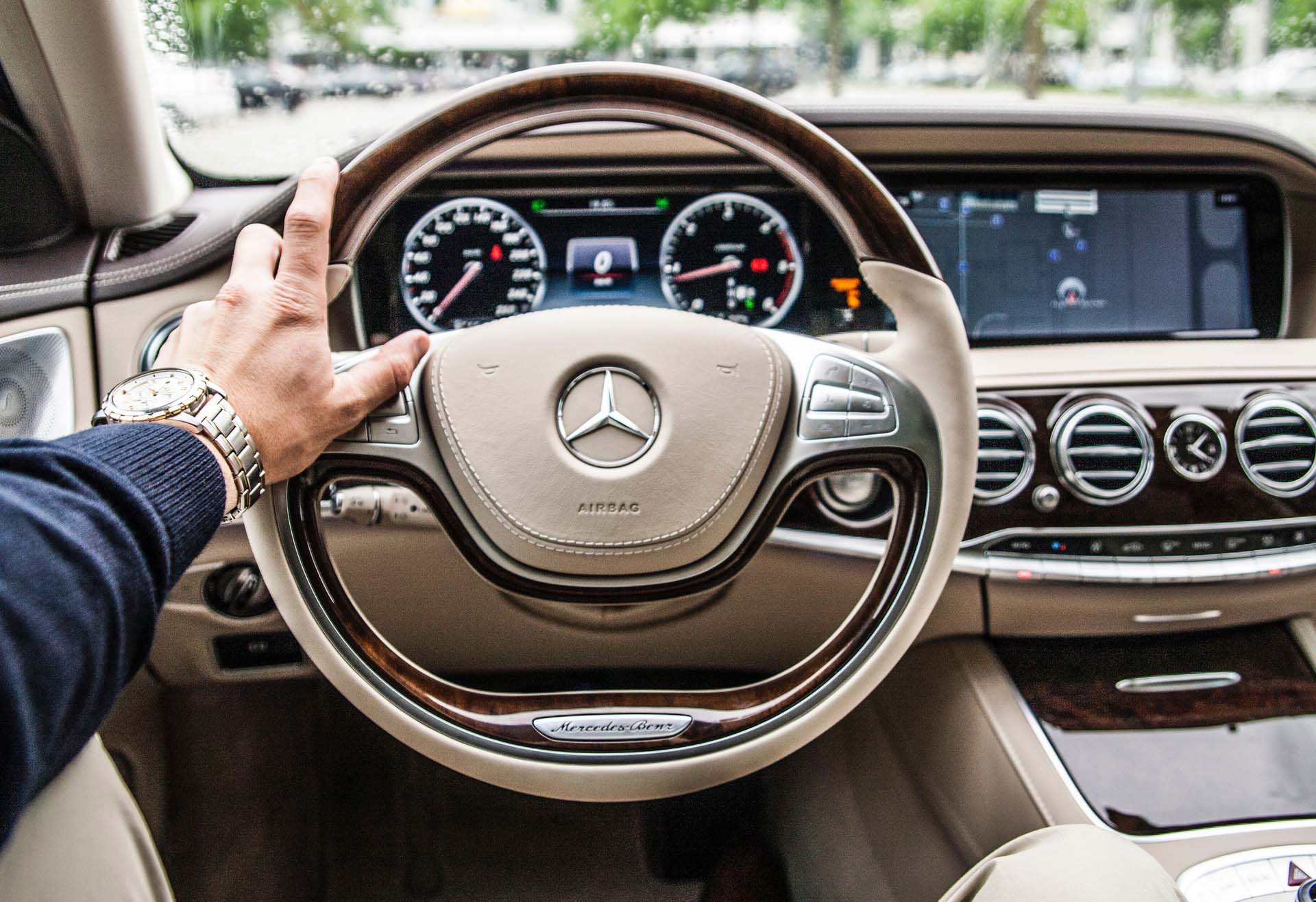 Hand on a Mercedes Benz steering wheel