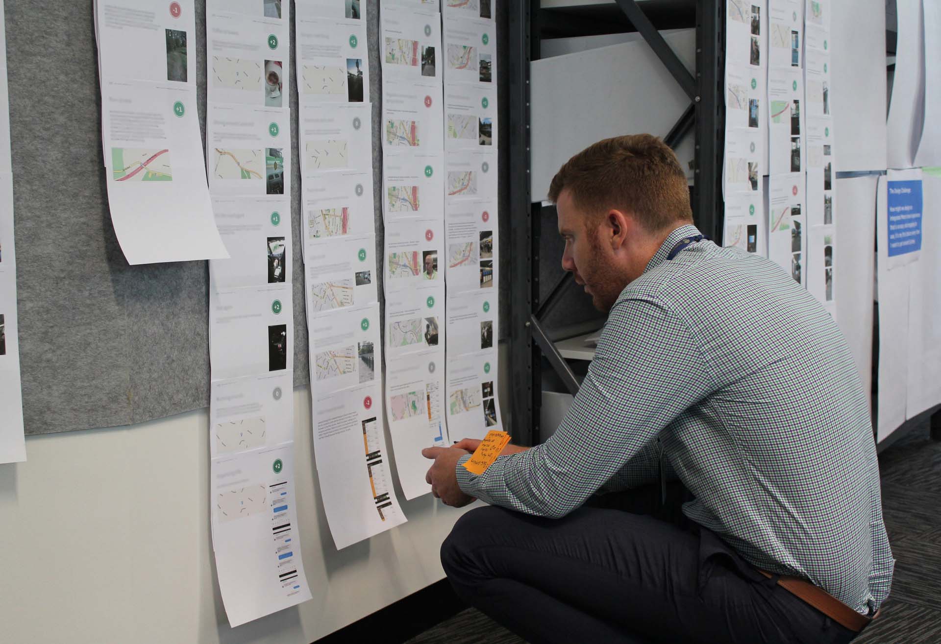 Crouched man reading a customer experience strategy display