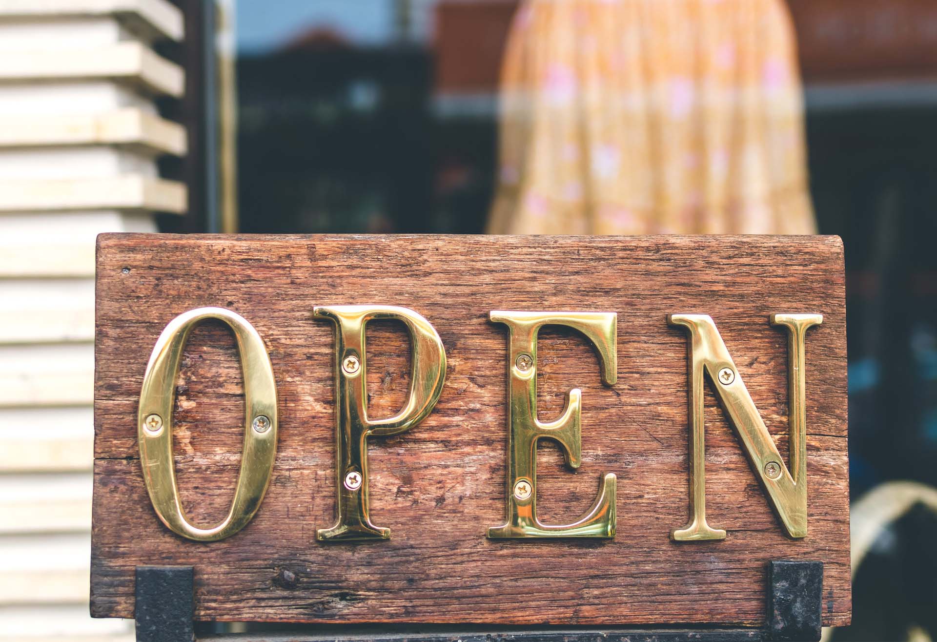 Open sign in a store front representing the eight new rules of customer service