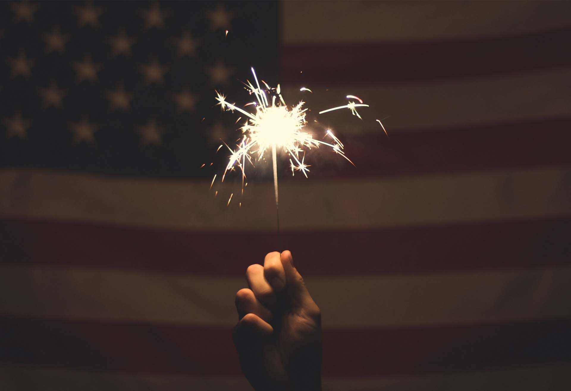 Sparkler in front of an American flag representing Service Design delight