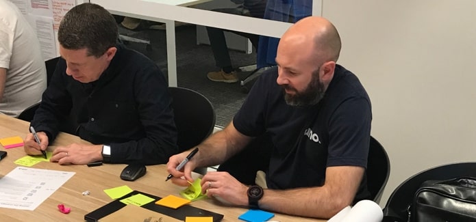 Uno stakeholder workshop; stakeholders writing on post-it notes during activity