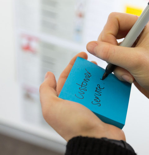 Customer service being written on a post-it note