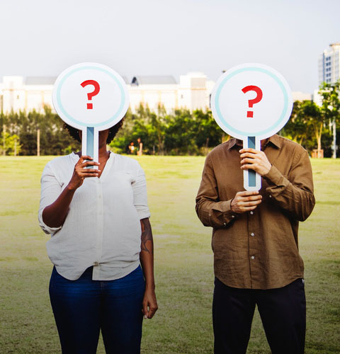 Two people holding up question mark signs against their face to depict customer study