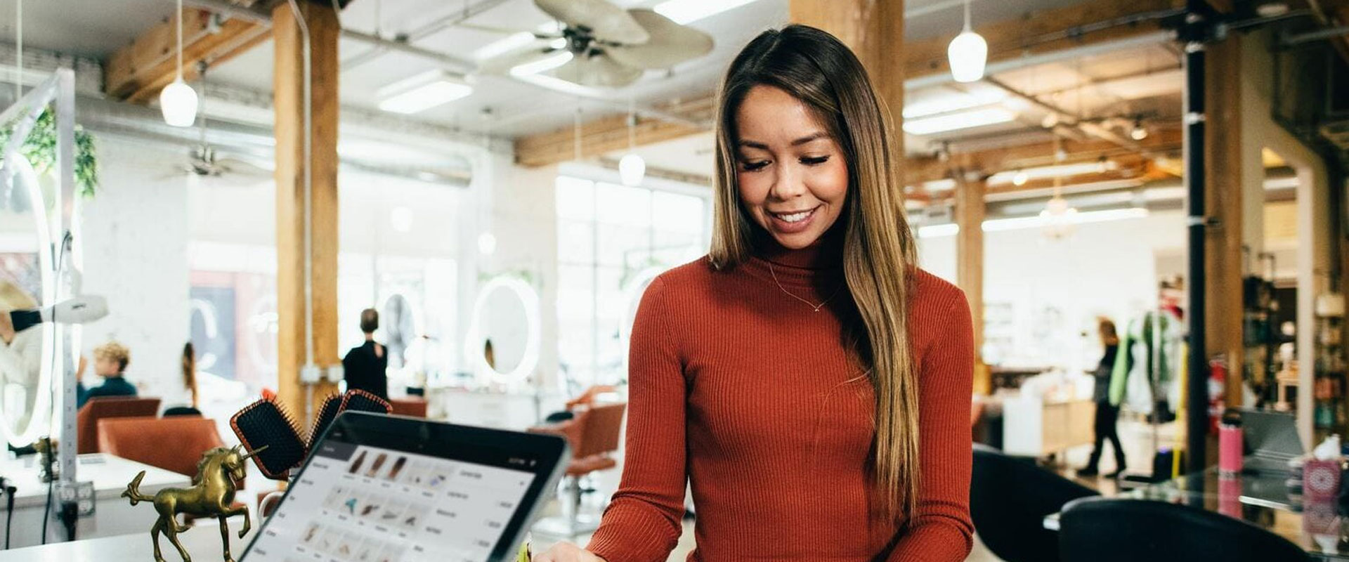 Lady smiling as she pays for her purchase at the register.