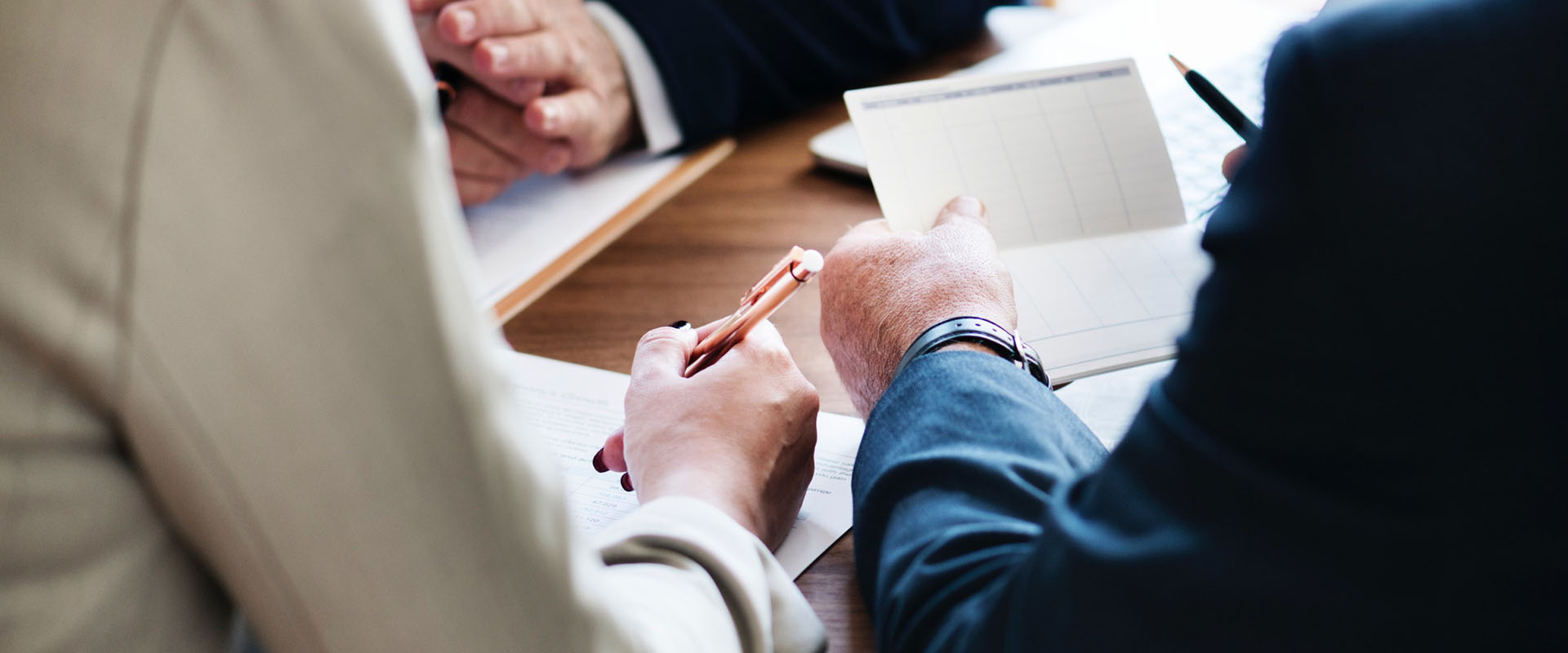 Three people looking at documents in a business meeting