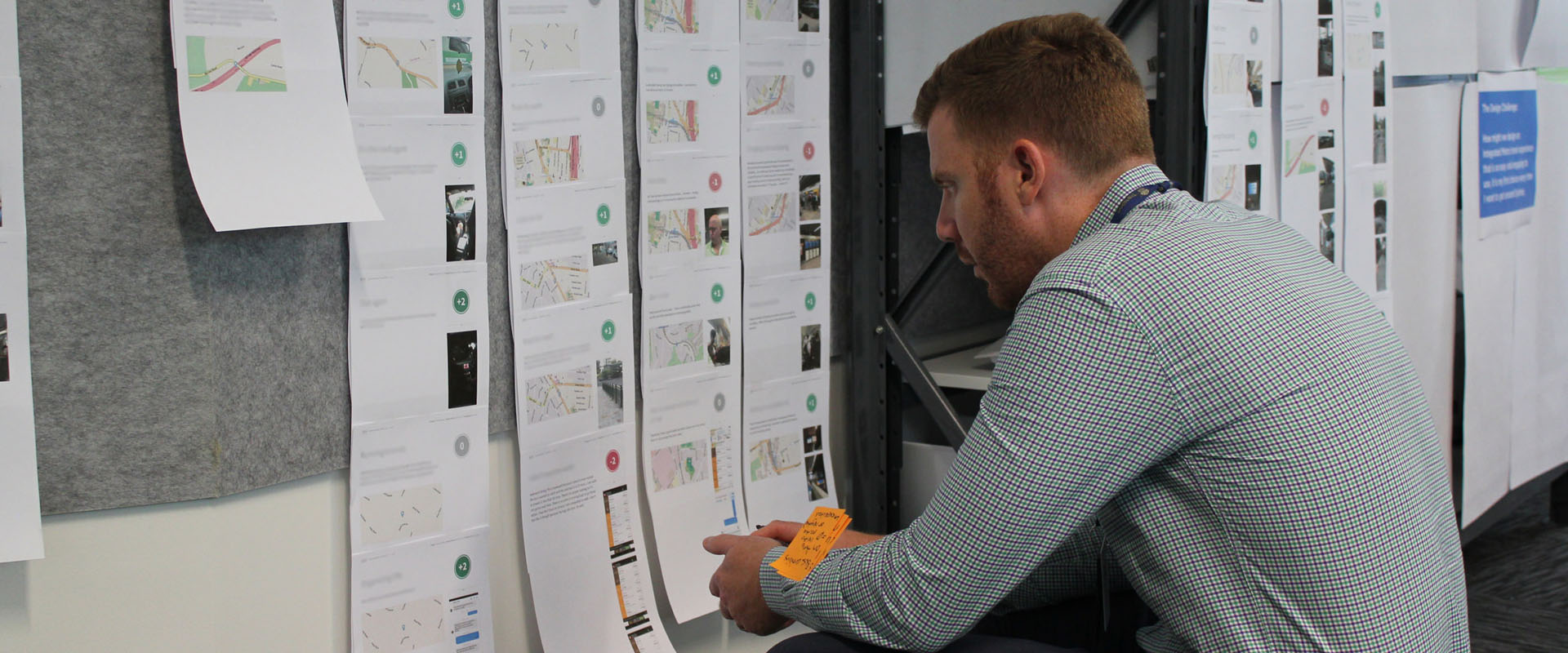 Crouched man reading a customer experience strategy display