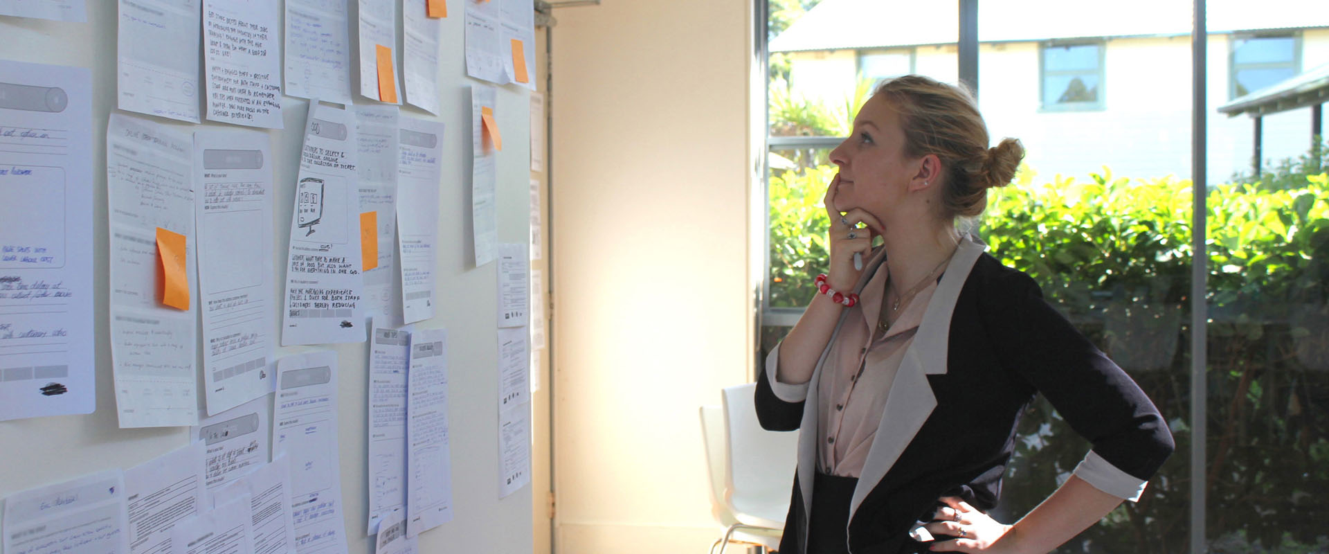 Woman thinking about a wall of Service Design information