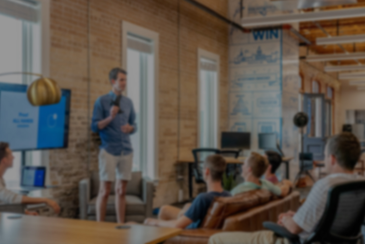 Facilitator presenting to a seated team in an open plan office