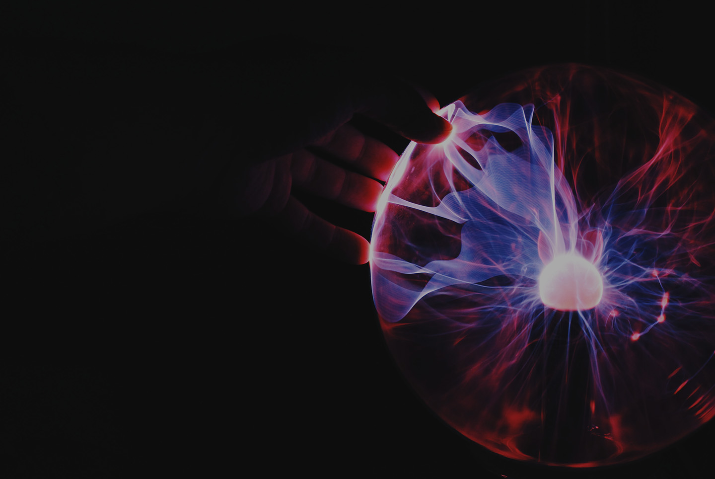 Abstract render of glowing filaments radiating from a bright core on a black background